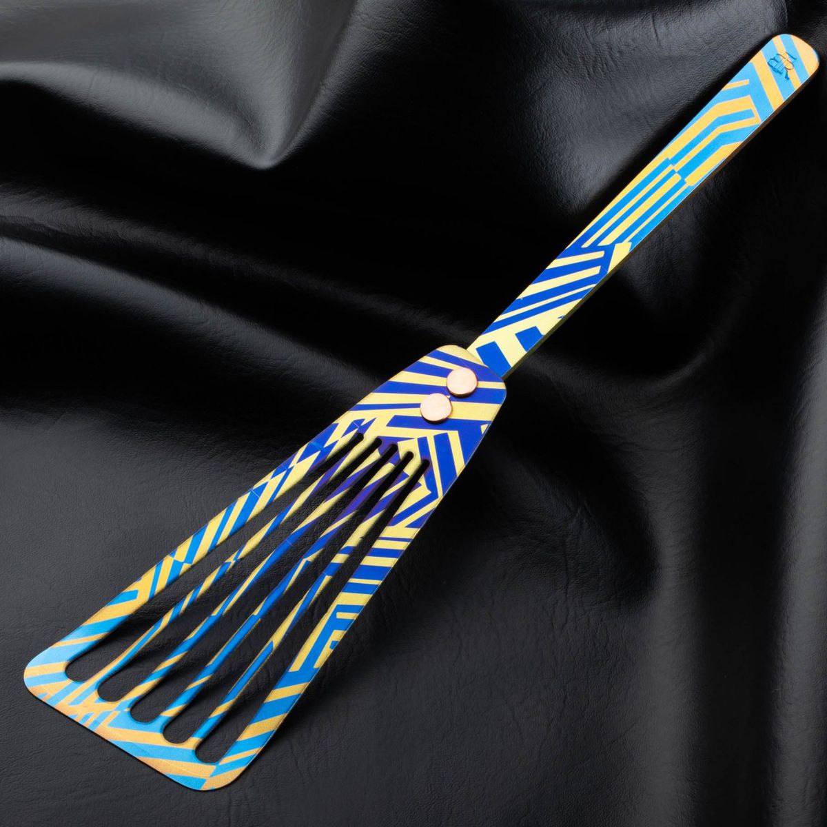 A fish spatula with a yellow and blue pattern