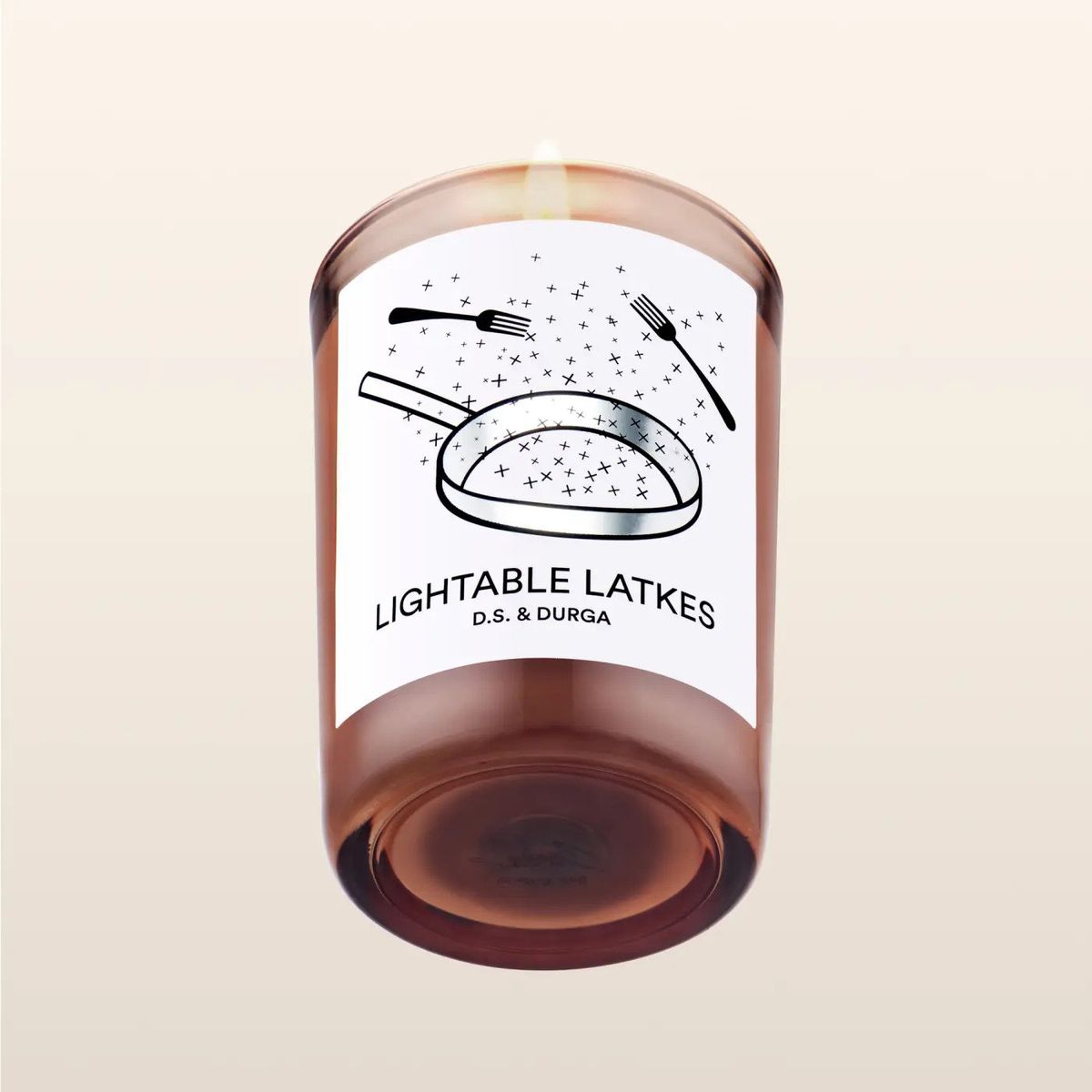 A candle with a label that reads LIGHTABLE LATKES