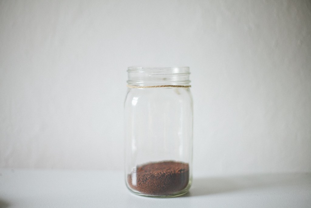 A glass jar of coffee grounds steeping for cold brew