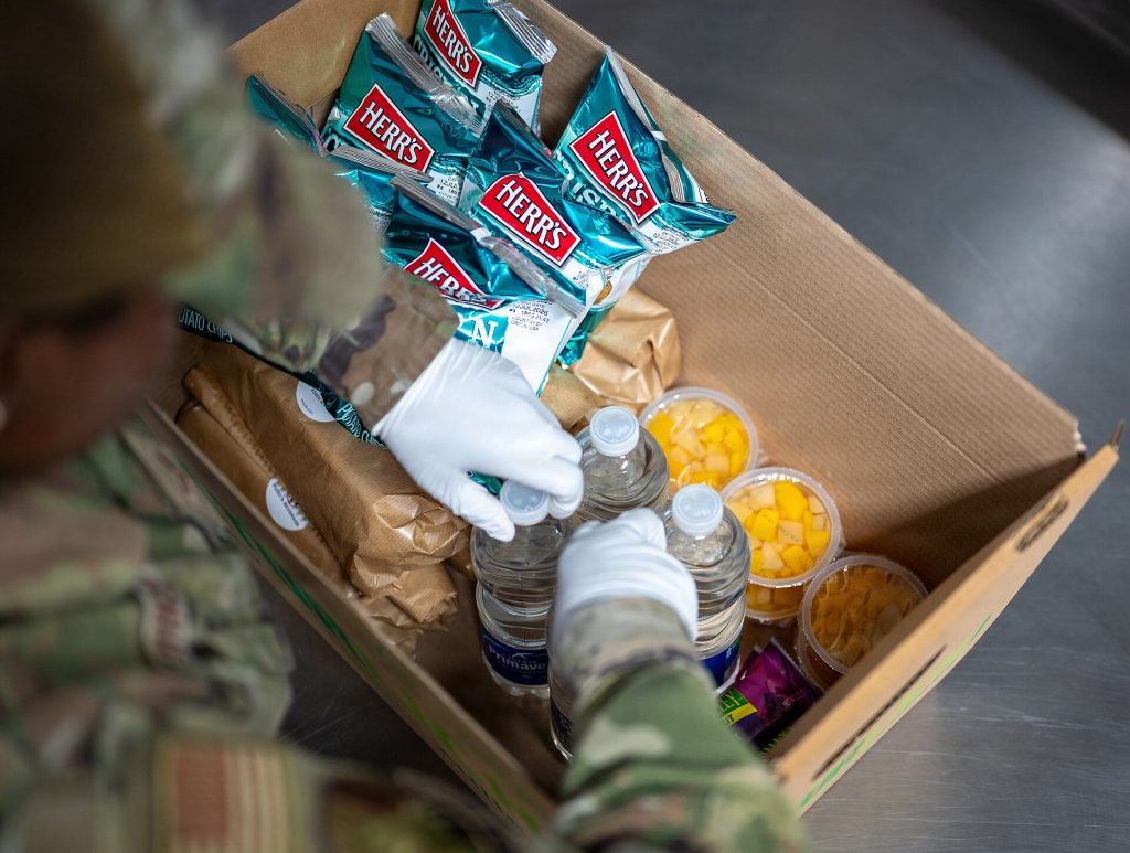 Boxes of delivered food stacked in a commercial kitchen receiving area