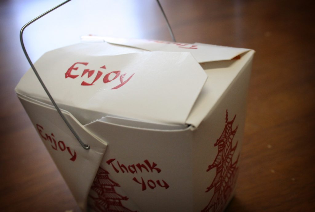 Stacked takeout food boxes on a restaurant counter