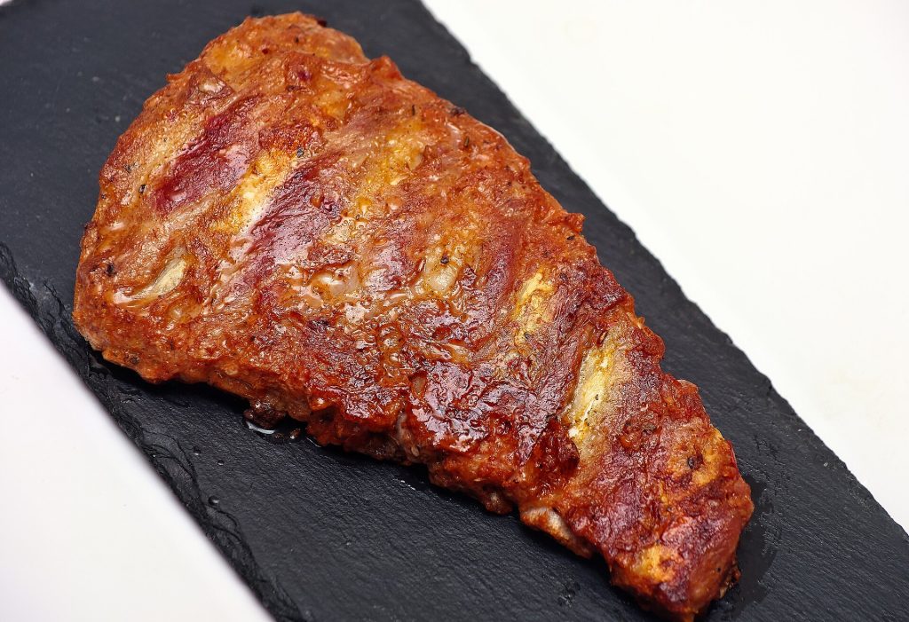 A rack of barbecue pork ribs on a wooden board