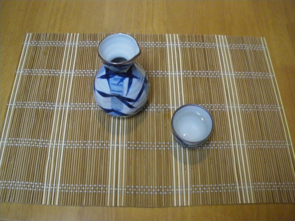 A ceramic sake carafe with small ochoko cups