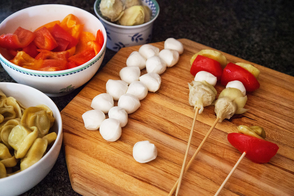 skewer kebabs with marinated vegetables artichoke hearts sweet peppers bocconcini cheese and vinaigrette dress