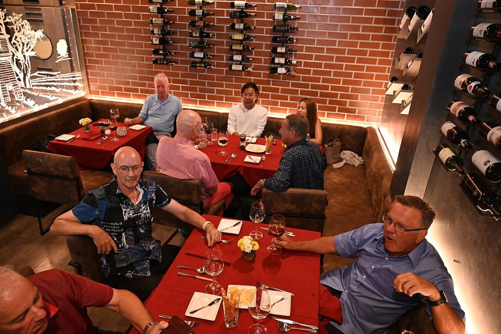 A group of diners sharing an evening meal at a wine-bar restaurant