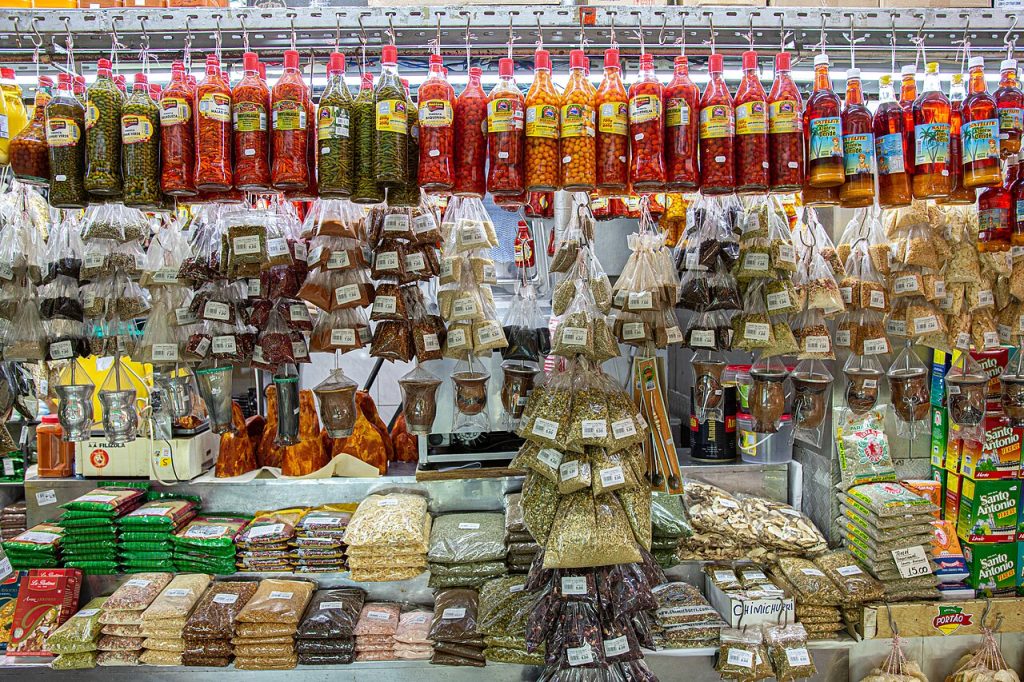 A market stall stacked with spices, dried goods and bottled sauces