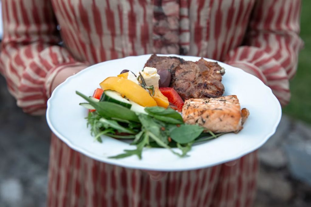 Plate of small dishes with grilled meat, salmon and fresh salad for a travel-inspired dinner